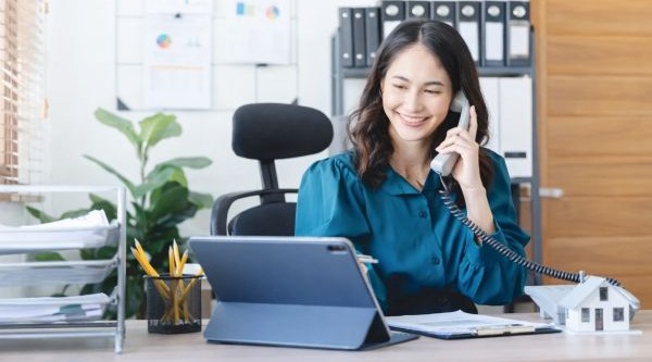 Real estate agent making prospecting calls using an expired listing script at her desk