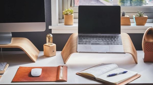 Real estate marketing workspace with laptop, desk, and planning tools for email campaigns and lead generation